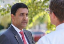 Armed Settlers Detain Congressman—With U.S. Rifles Two professionals engaged in conversation outdoors