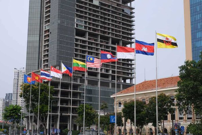 shutterstock_2151668523 Row of ASEAN national flags in front of city buildings