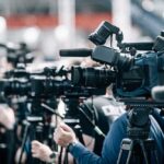 Cameras MUZZLED: Europe Redraws Women’s Sports Row of cameras set up for a press event