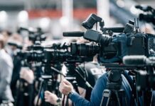 Row of cameras set up for a press event