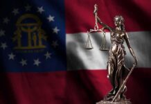 Lady Justice statue in front of Georgia state flag