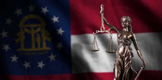 Lady Justice statue in front of Georgia state flag