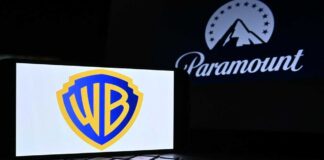 Warner Bros logo displayed on a smartphone with Paramount logo in the background