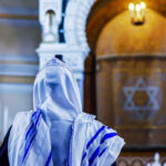 Jewish Lawmakers Shut Out—Fury Erupts A person wearing a tallit in a synagogue during prayer