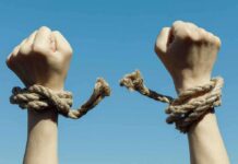 Culture War Twist: Ideology Linked To Violence? Hands breaking free from rope bindings against a clear blue sky