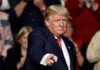 GOP Rumble: Trump Freezes Out Thune man in suit pointing toward the camera at an event