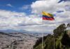 Ecuador flag flying over a hillside city
