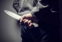 person holding a large knife behind their back