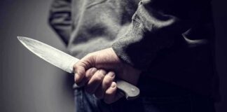 person holding a large knife behind their back