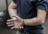 Firestarter Hunt Ends With Cuffs person in handcuffs with hands behind back