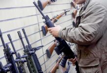 Texas Judge Torpedoes Key Gun Controls Person examining a black rifle in a gun store