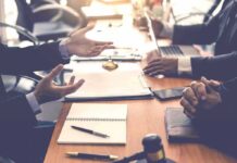 Business meeting with hands gesturing over a conference table