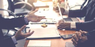 Business meeting with hands gesturing over a conference table