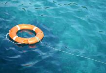 Orange life buoy floating on blue water