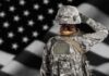 Troops Get $10K? Hazard Pay Reimagined Soldier in camouflage saluting before a U.S. flag