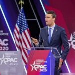 Speaker in suit at CPAC podium on stage