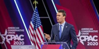 Speaker in suit at CPAC podium on stage