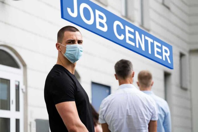 Man in face mask standing in line outside job center