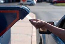 Mailbox Trap Exposes Ballot Weak Spot Hand mailing an envelope into a blue mailbox