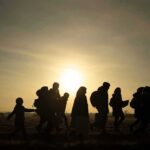 silhouettes of people walking at sunset