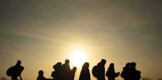 silhouettes of people walking at sunset