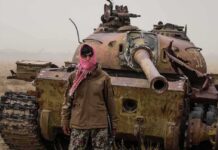 UN Files Reveal Chilling Afghan Boy Abuse Man in scarf stands before a rusted tank in a barren field