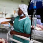 Scary Detection Gap — Virus Got A Head Start IV drip and blood pressure gauge in a hospital ward