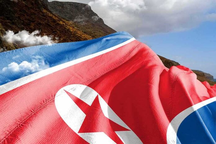 shutterstock_2254423557 North Korea flag draped over a mountainous landscape