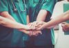 medical team stacking hands in unity