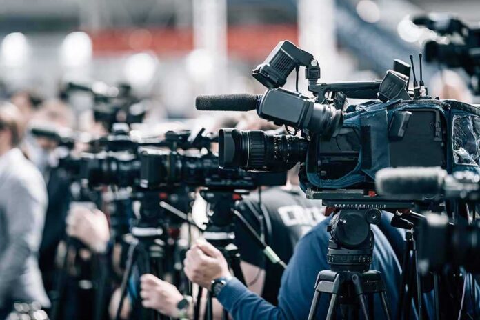 Broadcast cameras on tripods at a press event