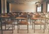 Empty classroom with rows of wooden desks and chairs