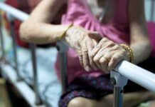 Elderly Eviction – Spain’s Rent Crisis Explodes Elderly person’s hands resting on a hospital bed rail