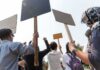 Riot Police SWARM – The Hague Boils Over Group of people holding protest signs outdoors