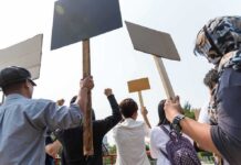 Group of people holding protest signs outdoors