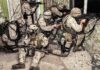 Late-Night Tip Triggers Major Lockdown soldiers in camouflage gear take positions inside a damaged building