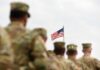Mall Reserve Cracked Open For Heroes U.S. flag flying above a formation of soldiers in uniform
