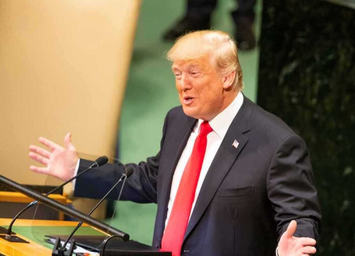shutterstock_1189318330 Donald Trump speaking at a podium with arms outstretched