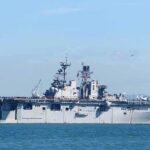 Ballistic Salvo Fizzles—Payback Hits Hard Aircraft carrier sailing on calm blue water
