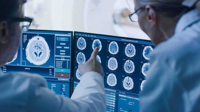 shutterstock_1243951690-1 Doctors reviewing brain MRI scans on multiple monitors