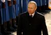 European Seizures Trigger Kremlin Payback Threat man in dark coat walks past honor guard