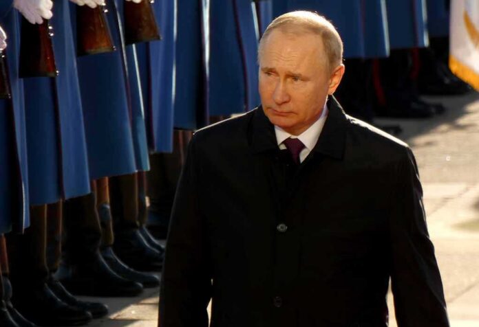 man in dark coat walks past honor guard
