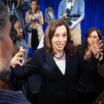 Kamala Harris speaks to a crowd as Maya Harris stands nearby
