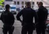 Police Names Blacked Out Over ICE Ties Police officers stand on a city street