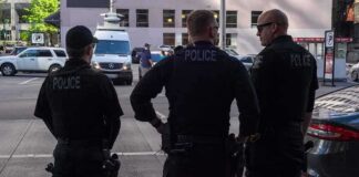 Police officers stand on a city street
