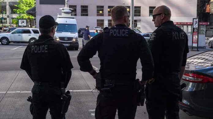 Police officers stand on a city street