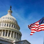U.S. Capitol dome with American flag against blue sky