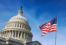 U.S. Capitol dome with American flag against blue sky