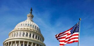 U.S. Capitol dome with American flag against blue sky