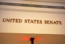 Tillis Torches Hegseth — Confidence Gone Sign displaying United States Senate in a government building