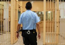 LAWLESS? Sheriffs Claim ‘Sanctuary’ Endangers Communities corrections officer walking through prison corridor